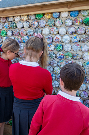 School children with ecobrick wall